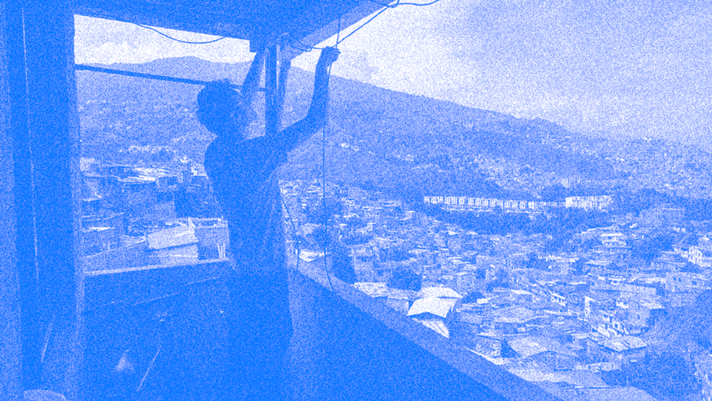 A red_medeillin member installing a network node on an apartment eave on the outskirts of Medellin, Colombia.